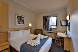 逊邱伦Road Lodge Centurion的配有一张床和一张书桌的酒店客房
