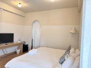萨拉耶La Moon House的卧室配有白色的床和电视。