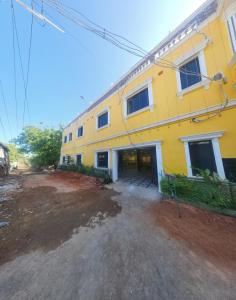 KottakupamParadise Golden Residency的前面有一条土路的黄色建筑