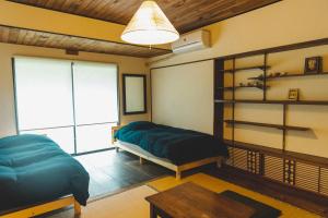 SetoMasukichi 古民家宿ますきち 駐車場無料的一间卧室配有一张床、一张桌子和一个窗户。
