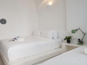 怡保Ipoh Santorini Hideaway - Hotel Inspired的白色卧室配有一张带白色床单的大床