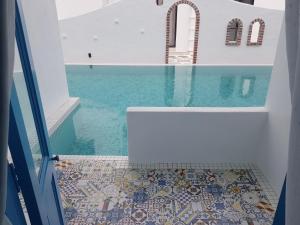 怡保Ipoh Santorini Hideaway - Hotel Inspired的浴室铺有马赛克地板,配有浴缸。