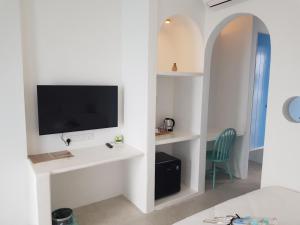 怡保Ipoh Santorini Hideaway - Hotel Inspired的一间设有床铺和墙上电视的房间