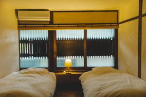SetoMasukichi 古民家宿ますきち 駐車場無料的一间卧室设有两张床和一扇带灯的窗户