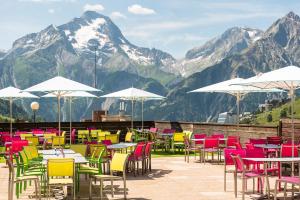 莱德萨阿尔卑斯Villages Clubs du Soleil - LES 2 ALPES的一组以山为背景的桌椅