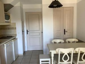 格罗斯皮耶尔雷Duplex (5pers) dans village vacances en Ardèche的厨房配有桌椅