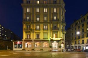 日内瓦国际终点站酒店的夜幕降临的城市街道上一座高大的黄色建筑