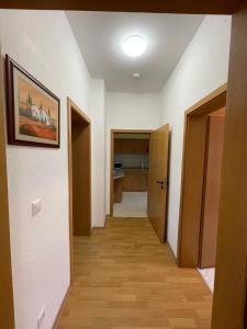 茨维考Ferienwohnung im Zentrum Zwickaus的走廊设有白色的墙壁和木地板