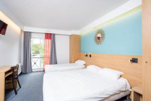 蒙热内夫尔Villages Clubs du Soleil - MONTGENEVRE的酒店客房配有两张床和一张书桌