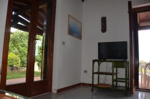 波尔托奥蒂罗卢Via dei Ciclamini - FPO-NETT01的客厅位于隔壁,配有平面电视。