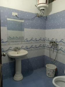 钱德加尔MID CITY HOTEL & RESTO的蓝色和白色的浴室设有水槽和淋浴
