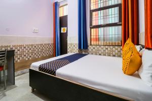 加济阿巴德SPOT ON APNA LOUDGE的一间卧室配有橙色和蓝色窗帘的床