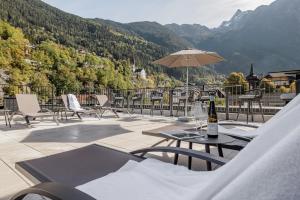 厄茨MYALPS Tirol的庭院配有桌椅和遮阳伞。