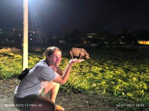 索拉哈Hotel National Park Sauraha- Homely Stay and Peaceful Location的一位妇女正在用大象捕杀一只薯条