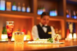 别府Spa and Resort Hotel Solage Oita Hiji Beppuwan的坐在酒吧里吃一盘食物的男人