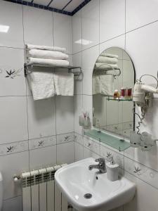 撒马尔罕Hotel Marvarid的浴室配有盥洗盆、镜子和毛巾