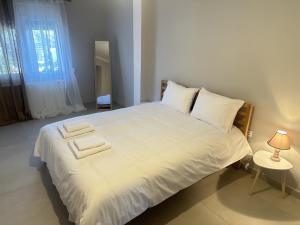 拉夫蒂港Seaside Luxury Apartments的卧室配有一张带灯的白色大床