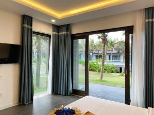 潘切Starlight Villa Beach Resort & Spa的一间卧室设有一张床和一个大窗户