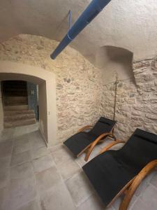 阿科Arqué Apartments - Arco Centro的一间设有两把椅子和石墙的房间