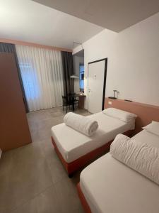 阿科Arqué Apartments - Arco Centro的酒店客房设有两张床和一张桌子。