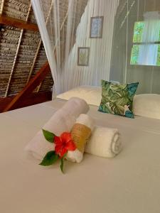 Ile aux NattesAurora Lodge的一张带两条毛巾的床,上面有花