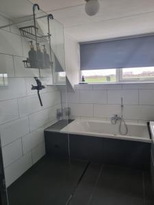 De Morgenzon的白色的浴室设有浴缸和窗户。