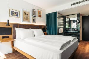维也纳Hotel Schani Uno City的一间带白色大床的卧室和一间浴室
