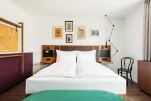 维也纳Hotel Schani Uno City的卧室配有一张白色大床和一把椅子