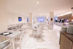 贝尼多姆FLEMING PLAYA PONIENTE的一间设有白色桌子和白色椅子的餐厅