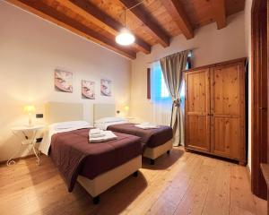 圣马尔蒂诺博纳尔贝尔戈科尔特佩莱格里尼农家乐的一间卧室设有两张床、一张桌子和一个窗口