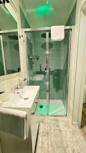 利多迪耶索罗Hotel Cristina的一间带玻璃淋浴和水槽的浴室