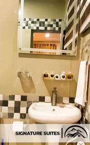 Ado EkitiLA GRANITA HOTEL AND SUITES的一间带水槽和镜子的浴室