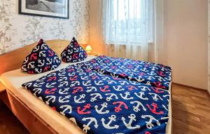 StubbenfeldeStunning Apartment In Klpinsee-usedom With Kitchen的一张带蓝色和红色毯子和枕头的床
