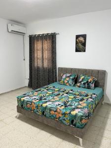 迈来亚App 2 chambres piscine privative 600m plage的卧室内一张带五颜六色棉被的床