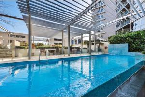 悉尼Cozy 2 Bedroom Apartment Darling Harbour的一座带天蓬的大型游泳池