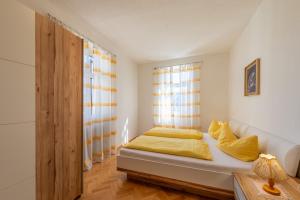 泰尔梅诺Ferienhof Franzelin的一间卧室配有一张带黄色枕头的床和一扇窗户