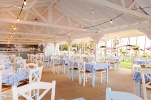 普罗塔拉斯卡沃马里斯海滩酒店的宴会厅配有白色的桌子和白色的椅子