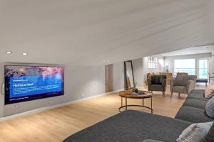 锡格吕菲厄泽Gagginn Siglo的客厅配有壁挂式大屏幕平面电视