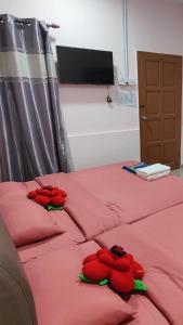 伯恩仓Santai Desa Chalet musleem 0nly的两张红色的床,上面有填充动物