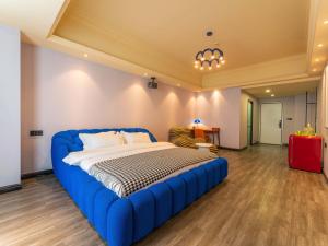 广州Wind sleeping Color Hotel - GuangZhou CHIME LONG Line7&18Nancun Wanbo STN的一间卧室,卧室内配有一张蓝色大床