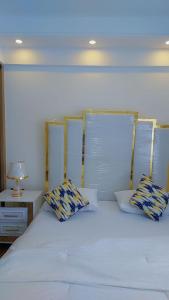 MutomoLuxury Apartment Lavington的一张带两个枕头的白色床和一张桌子上的台灯