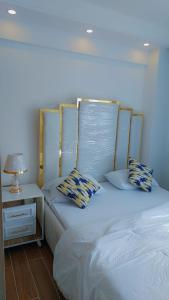 MutomoLuxury Apartment Lavington的一张带两个枕头的床和一张桌子上的台灯