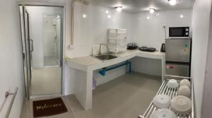 涛岛Amazing Inn Koh Tao的白色小厨房配有水槽和冰箱