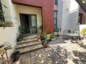 迪拜Townhouse Private Room的一座建筑旁的庭院,里面栽有盆栽植物