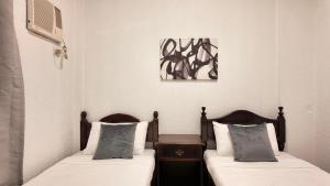 公主港CECILIAS INN的配有两张床垫的酒店客房内的两张床