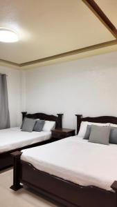 公主港CECILIAS INN的白色墙壁客房的两张床