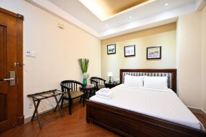 胡志明市Nicecy Hotel - Bui Thi Xuan Street的卧室配有一张床和一张桌子及椅子