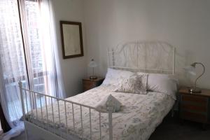 切尔诺比奥Cà di Strii的卧室配有白色的床头板和白色的床