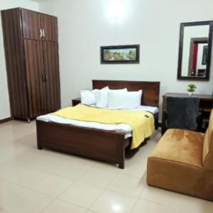 拉瓦尔品第Capital Guest Inn的一间卧室配有一张带黄毯和椅子的床