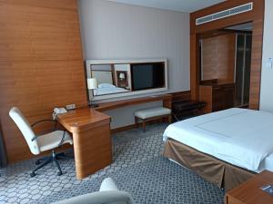 萨姆松阿尼蒙萨姆松酒店的酒店客房带一张床、一张书桌和一面镜子